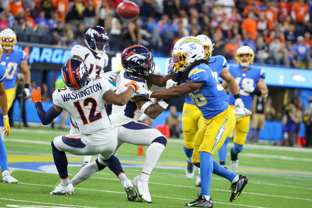 Denver's Montrell Washington (12) muffs a punt as teammate P.J. Locke blocks Ja'Sir Taylor (36) in overtime.