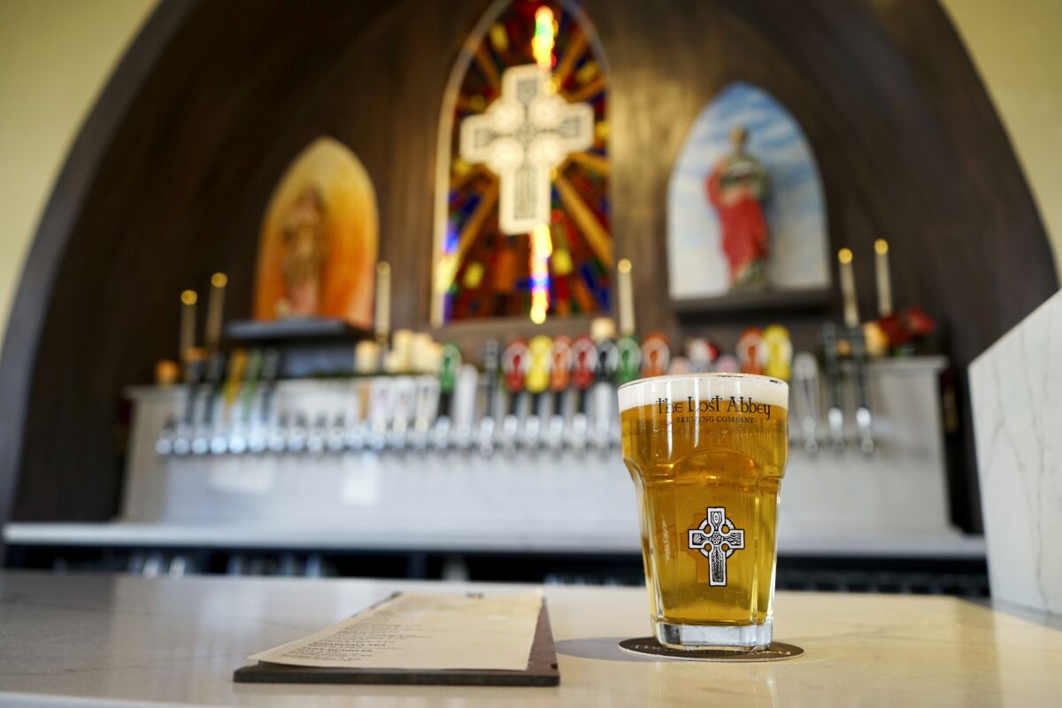 This photo provided by Adam Martinez shows inside The Lost Abbey in San Diego. The Lost Abbey brewing company opened a new location in December 2021 inside the shell of a Mexican Presbyterian church built in 1906. The brewery added pews, chandeliers, tapestries and even stained-glass windows to accentuate its slightly irreverent brand. (Courtesy of The Lost Abbey via AP)