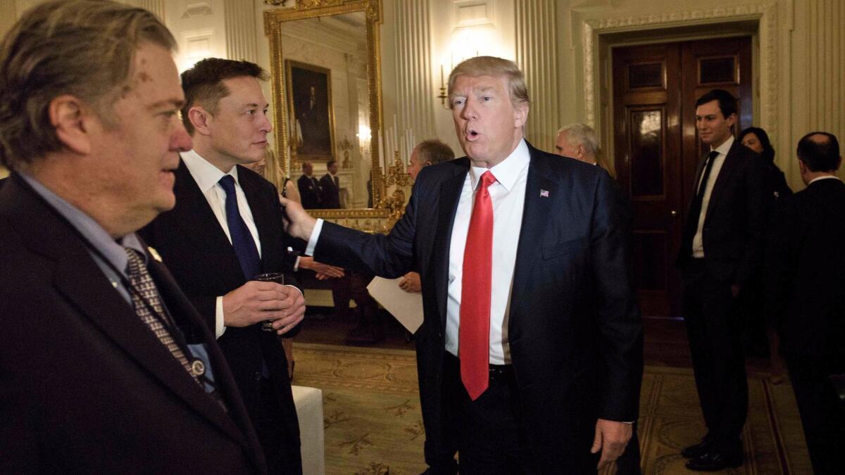 Senior advisor Stephen K. Bannon, left, watches as President Trump greets Elon Musk, SpaceX and Tesla CEO, at the White House in February. Musk quit the two presidential advisory councils he sat on over Trump's climate policies.