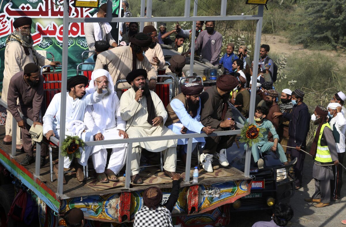 Leaders of Tehreek-e-Labiak Pakistan, a radical Islamist party, rally a protest march toward Islamabad, on a highway in the town of Sadhuke, in eastern Pakistan, Wednesday, Oct. 27, 2021. Violence at the anti-France Islamist rally in Sadhuke left at least one police officer and two demonstrators dead. They demanded the expulsion of France's envoy to Pakistan over publication of caricatures of Islam's Prophet Muhammad in France. (AP Photo/K.M. Chaudary)