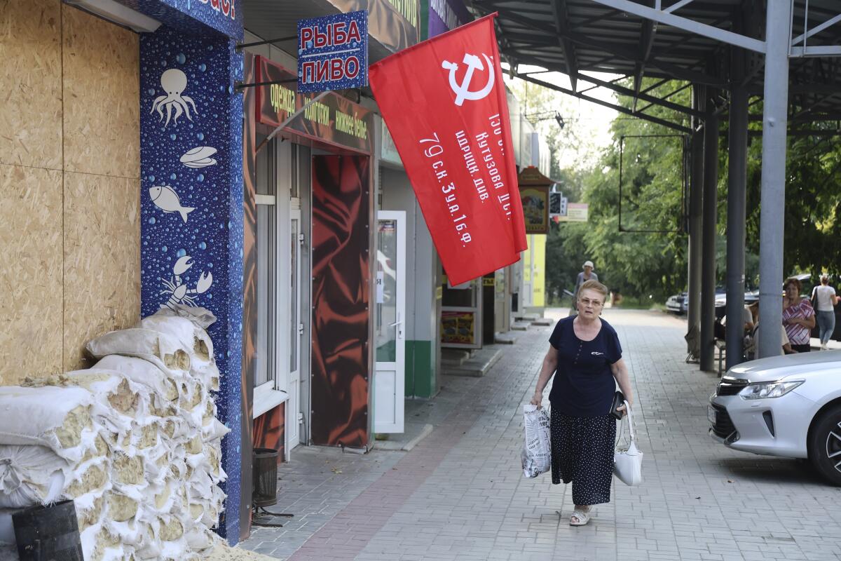 Woman walking under Russian victory banner in Donetsk, eastern Ukraine