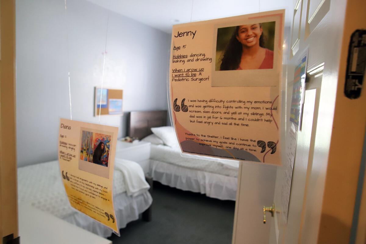 Pictures of youths with their hobbies are hung at the entrance of a bedroom at the Waymakers Huntington Beach Youth Shelter.