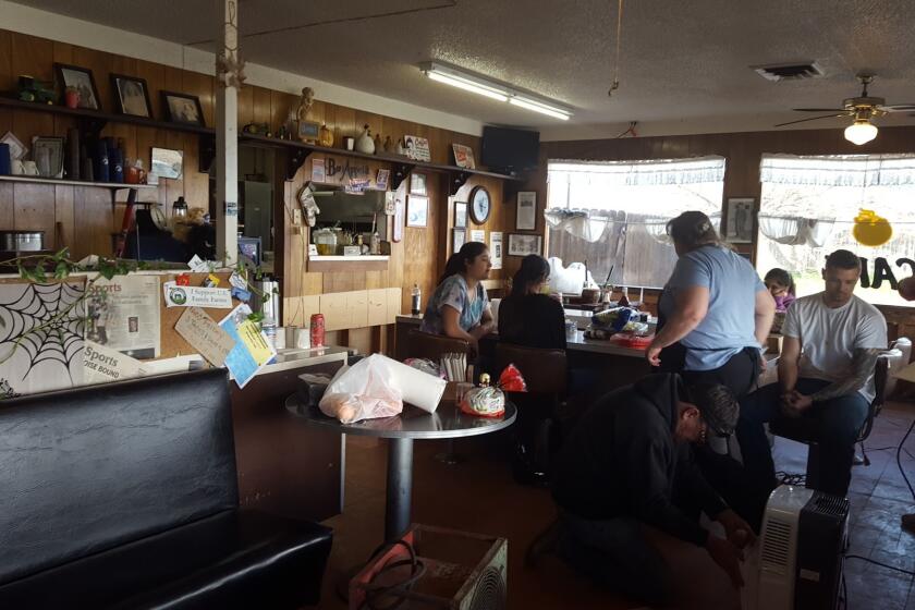 Community members gather Wednesday to help repair Kim's Country Cafe, which was damaged by floodwaters over the weekend.