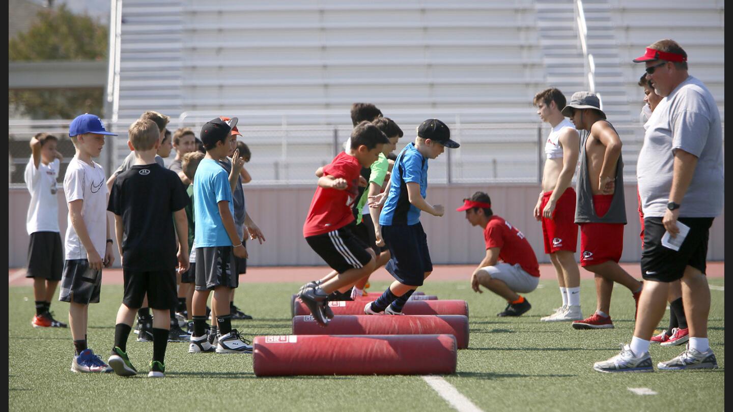 Camp participants go through skills drills as coaches keep a close eye on them at the Mike Reily Football Camp at Burroughs High School in Burbank on Tuesday, July 11, 2017. Six- to thirteen-year olds participate in the camp.