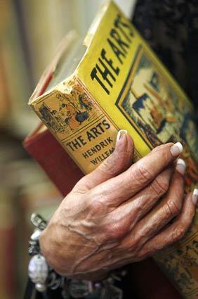 Alexandria Allan of Huntington Beach, who recalls having visited Acres of Books since she was 10 years old, holds two books she selected.