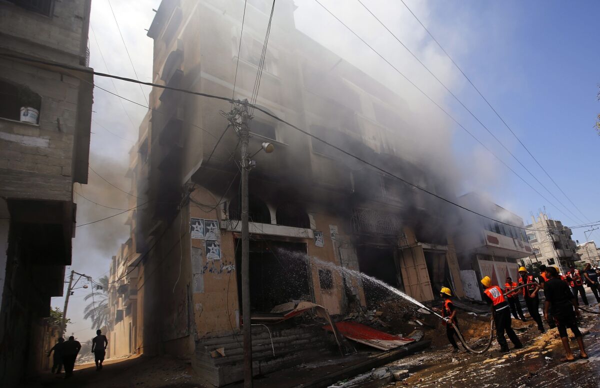 Palestinian firefighters douse a blaze in a house after Israeli airstrikes in Gaza City on Aug. 23.