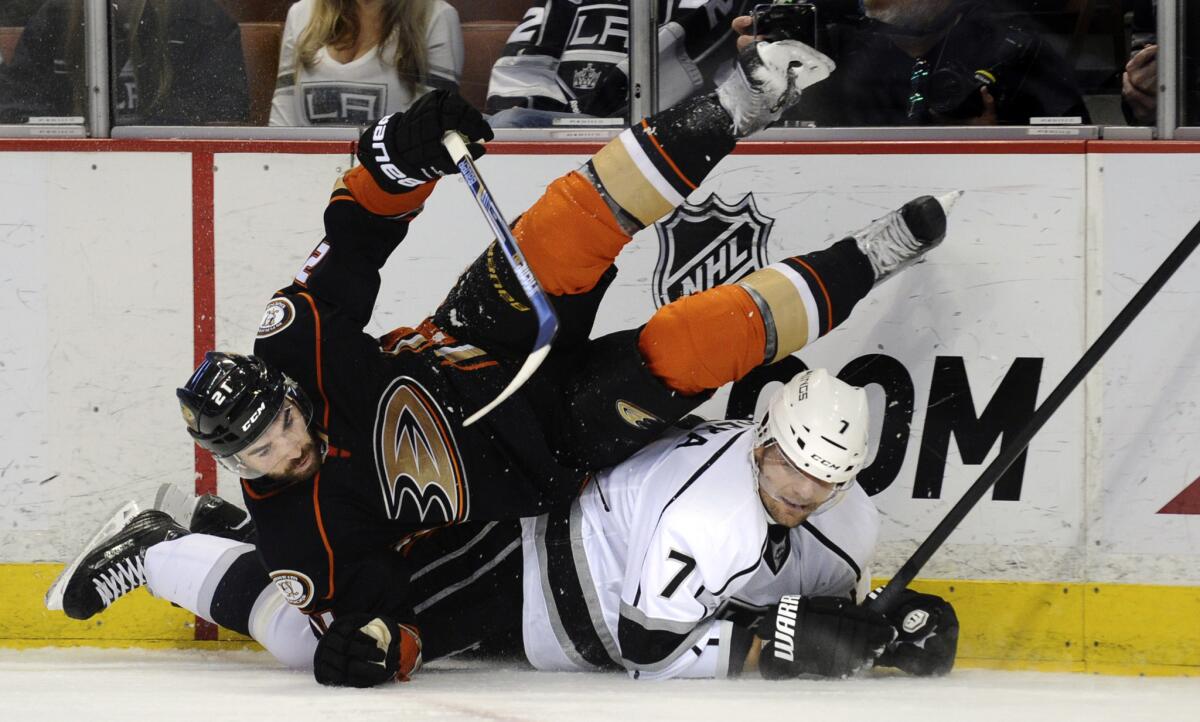 The newest of the Kings, Andrej Sekera, finds himself under the Ducks' Kyle Palmieri during the first period Friday at Honda Center.