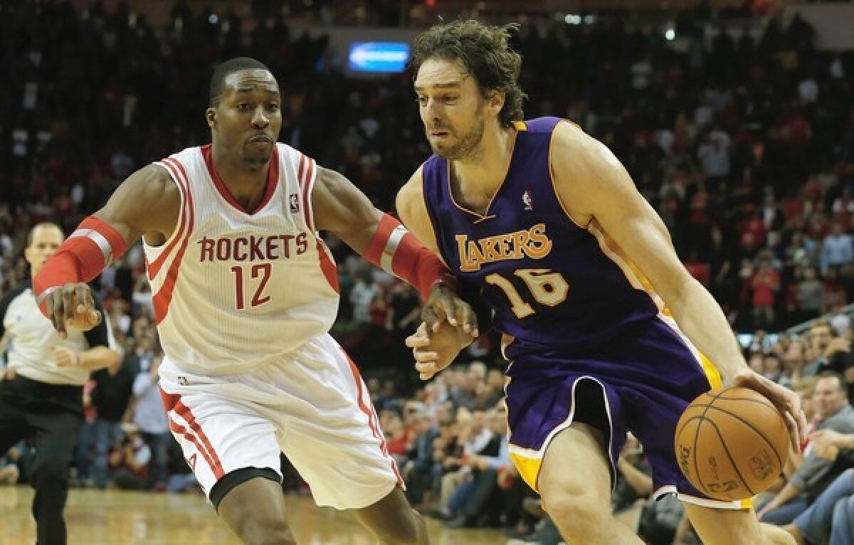 Lakers forward Pau Gasol drives to the basket as Houston Rockets center Dwight Howard defends during the Lakers' 99-98 win.