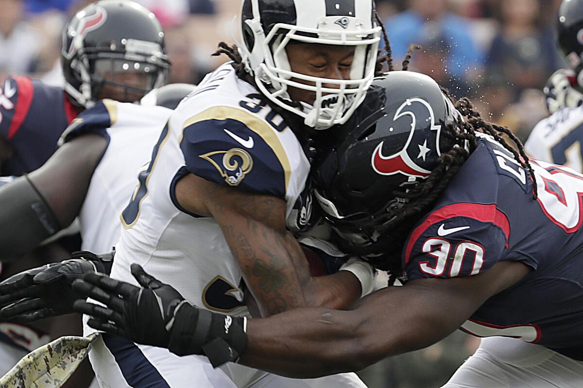 Texans linebacker Jadeveon Clowney delivers a hard blow while tackling Rams running back Todd Gurley for a loss in the first quarter at the Coliseum.