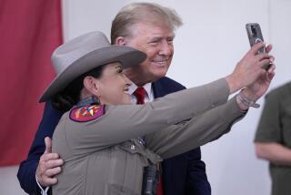 Republican presidential candidate and former President Donald Trump poses for a photo with a Texas state trooper as he helps serve food to Texas National Guard soldiers, troopers and others who will be stationed at the border over Thanksgiving, Sunday, Nov. 19, 2023, in Edinburg, Texas. (AP Photo/Eric Gay)