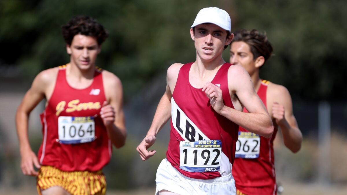 Laguna Beach High's Ryan Smithers surpasses two JSerra runners to win the CIF Southern Section Division 4 boys' cross-country final at the Riverside City Cross-Country Course on Nov. 17.