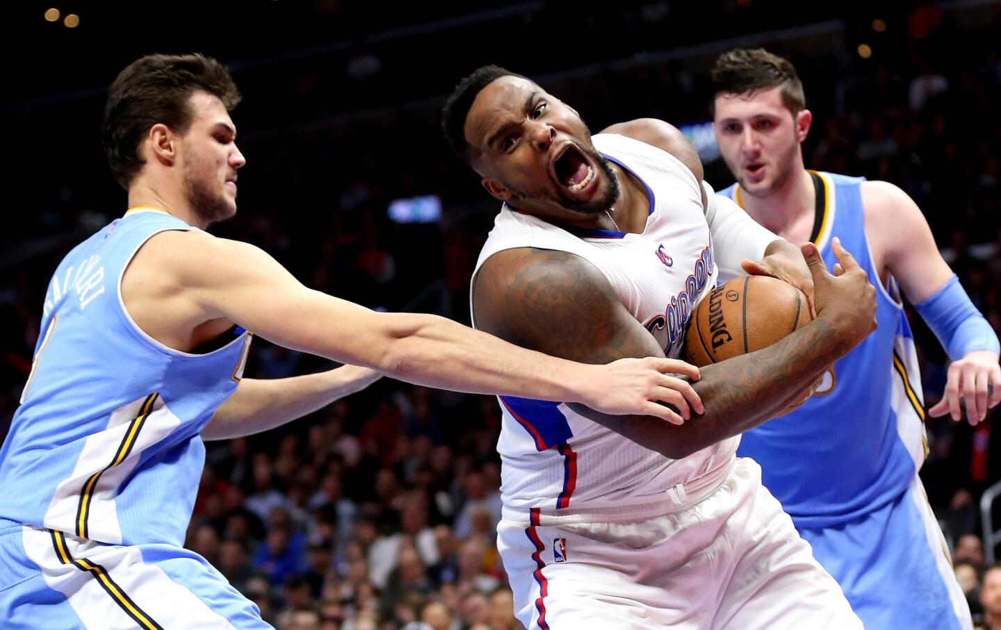 Clippers big man Glen Davis grabs a loose ball in front of Denver forward Danilo Gallinari on Monday at Staples Center. The Clippers beat the Nuggets, 102-98.
