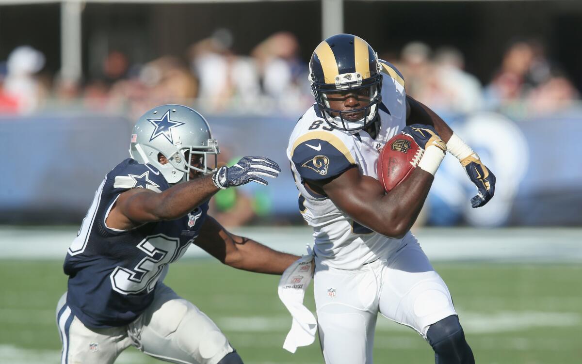 Rams' Brian Quick tries to evade Dallas' Anthony Brown on Aug. 13.