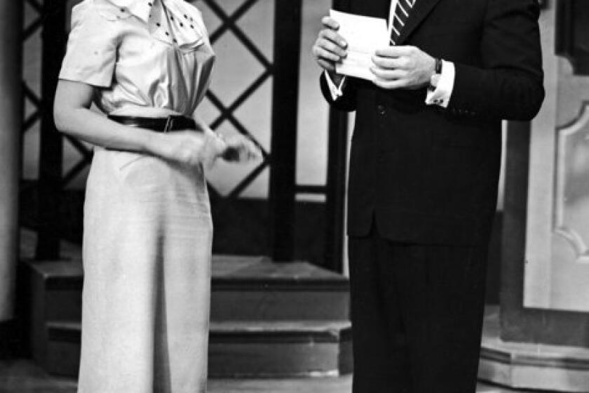Emcee Hal March stands with guest expert Dr. Joyce Brothers on the TV quiz show "The $64,000 Question" in 1957.