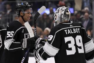 Los Angeles Kings right wing Quinton Byfield, left, celebrates with goaltender Cam Talbot.