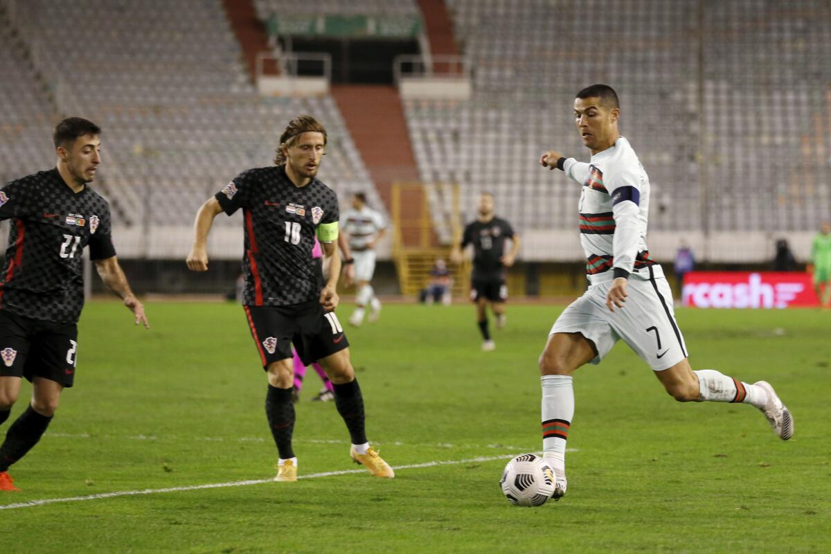 El delantero portugués Cristiano Ronaldo (7) encara a los croatas Luka Modric y Josip Juranovic, izquierda