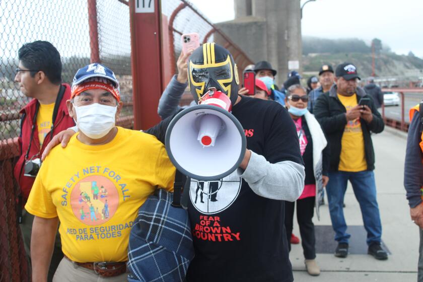 At a recent rally in San Francisco, Luis Valentan aka Compa Ñero, marches with the community in favor of a bill that would provide unemployment benefits for undocumented immigrants.