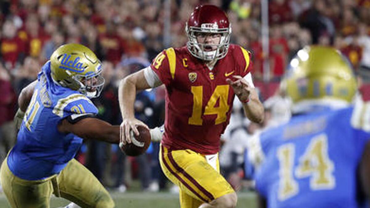 USC quarterback Sam Darnold scrambles out of the pocket and away from UCLA defensive lineman Jacob Tuioti-Mariner.