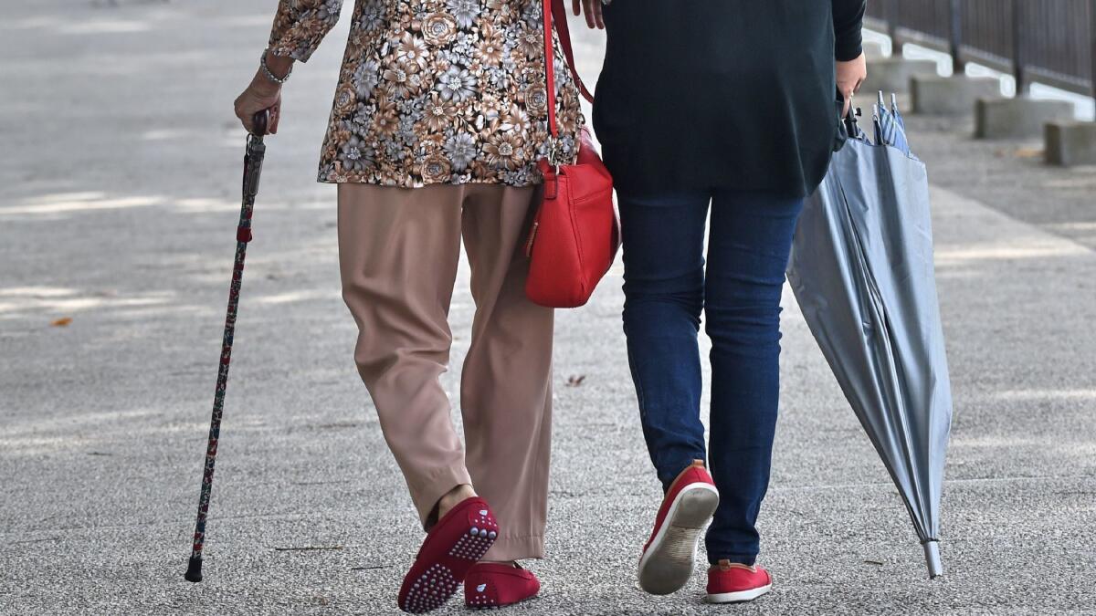 A caretaker assists an older woman out for a walk. A new report from the Centers for Disease Control and Prevention says that for America's senior citizens, the death rate from falls rose 31% over a decade.