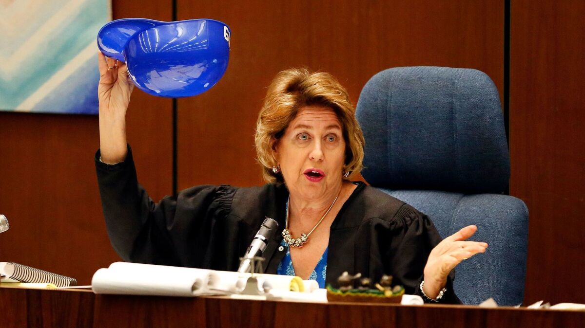 Judge Kathleen A. Kennedy picks a number from a souvenir Dodger helmet to select a replacement juror in the Grim Sleeper murder trial last year.