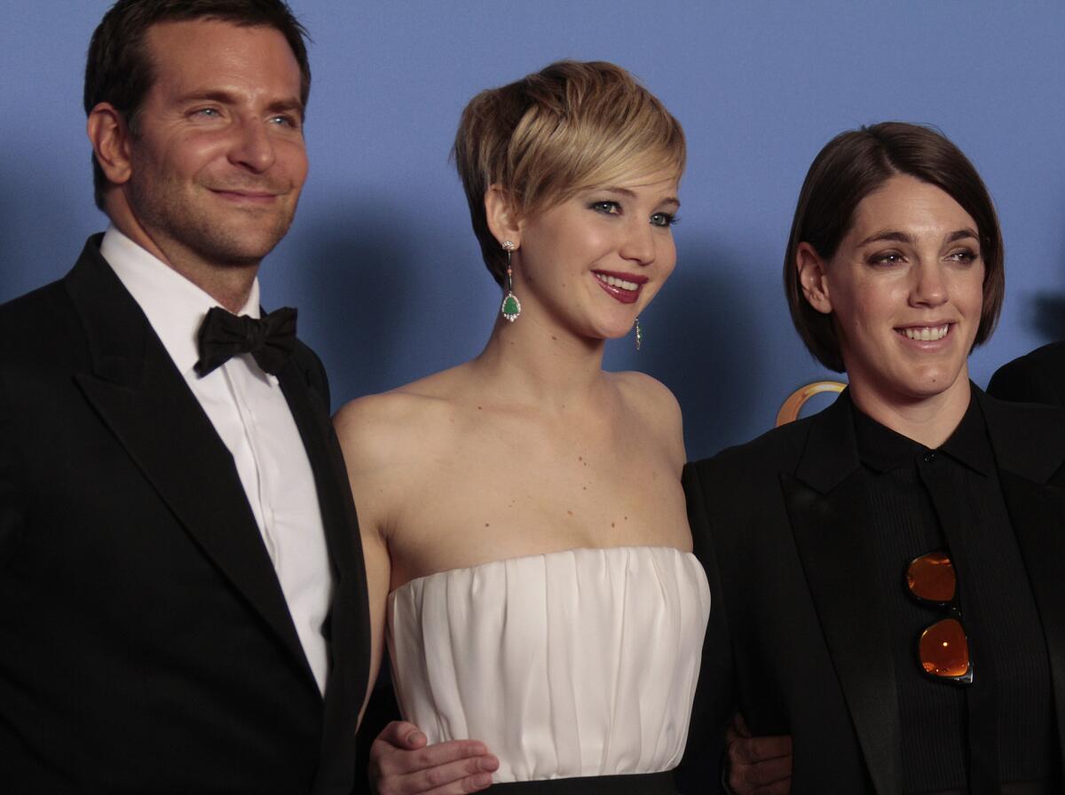 "American Hustle" producer Megan Ellison, right, with stars Bradley Cooper and Jennifer Lawrence at the 2014 Golden Globe Awards.