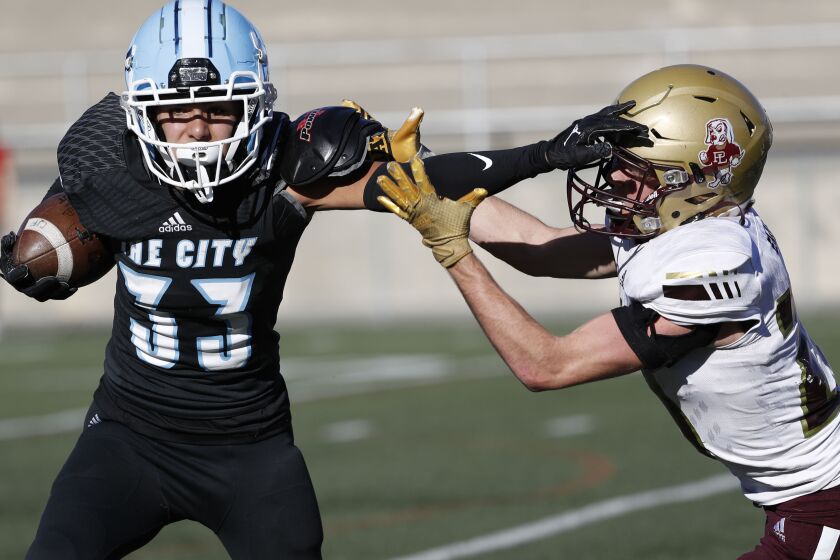 Santee, CA - November 25: University City's Jayden Daly (33) stiff arms Point Loma's Cameron Lucas (20) during the Division III San Diego Section football championship game at Southwestern College's Richard L. Jantz Stadium on Friday, Nov. 25, 2022 in Santee, CA. (Meg McLaughlin / The San Diego Union-Tribune)