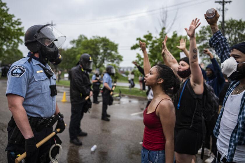 Protesters and police face each other during a rally for George Floyd in Minneapolis on Tuesday, May 26, 2020. Four Minneapolis officers involved in the arrest of the black man who died in police custody were fired Tuesday, hours after a bystander’s video showed an officer kneeling on the handcuffed man’s neck, even after he pleaded that he could not breathe and stopped moving. (Richard Tsong-Taatarii/Star Tribune via AP)