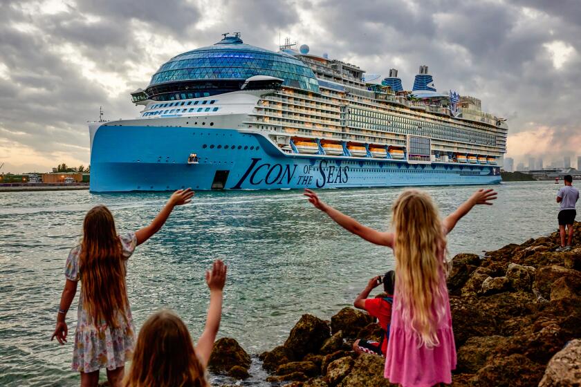 Onlookers wave as Royal Caribbean's Icon of the Seas, now the world's largest cruise ship, departs port in Miami.