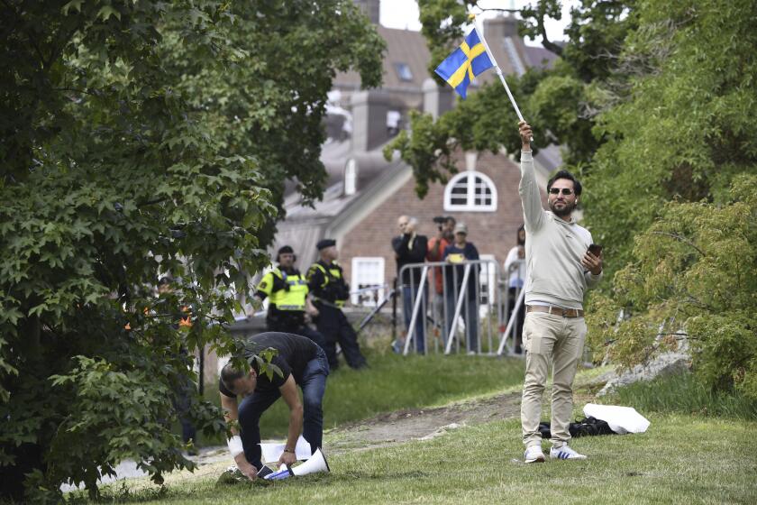 ARCHIVO - El iraquí Salwan Momika ondea la bandera sueca frente a la embajada de Irak en Estocolmo, 20 de julio de 2023, antes de quemar un ejemplar del Corán y una bandera iraquí. Momika, quien quemó varios ejemplares del Corán en Suecia, dijo a un diario el miércoles 27 de marzo de 2024 que pedirá asilo en la vecina Noruega ante una orden de deportación de las autoridades suecas. (Oscar Olsson/TT via AP, File)