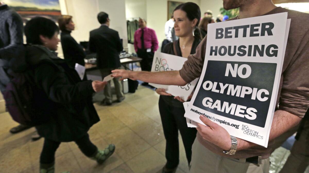 Jonathan Cohn, right, and Claire Blechman hand out fliers in Boston opposing the city's bid to host the 2024 Summer Olympic Games.