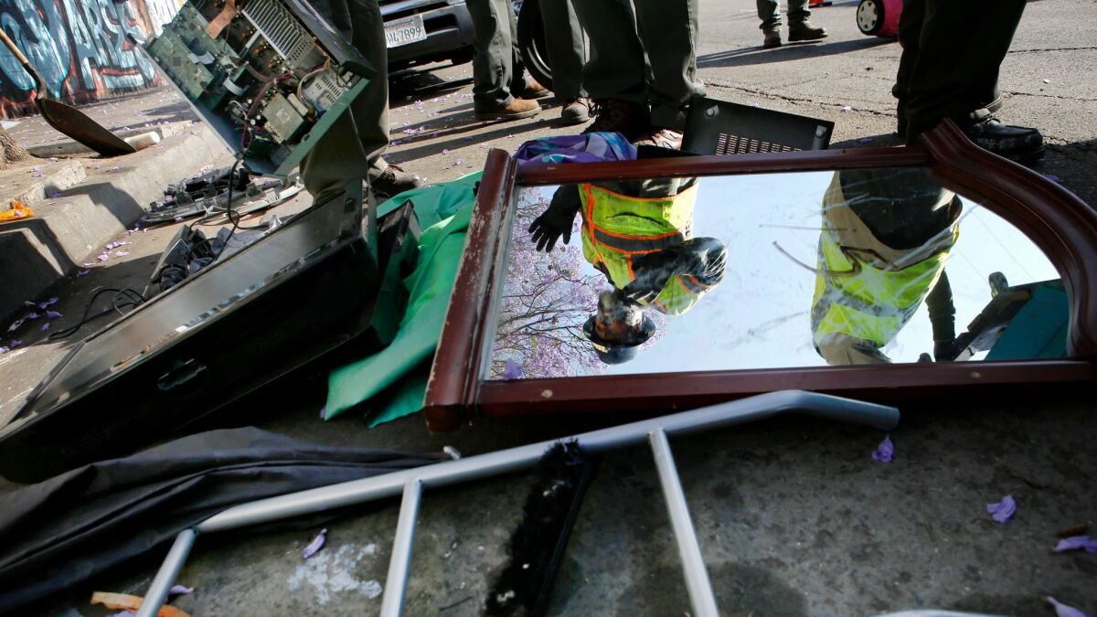 Sanitation workers dispose of waste during a sanitation cleaning in Los Angeles. (Christian K. Lee / Los Angeles Times)