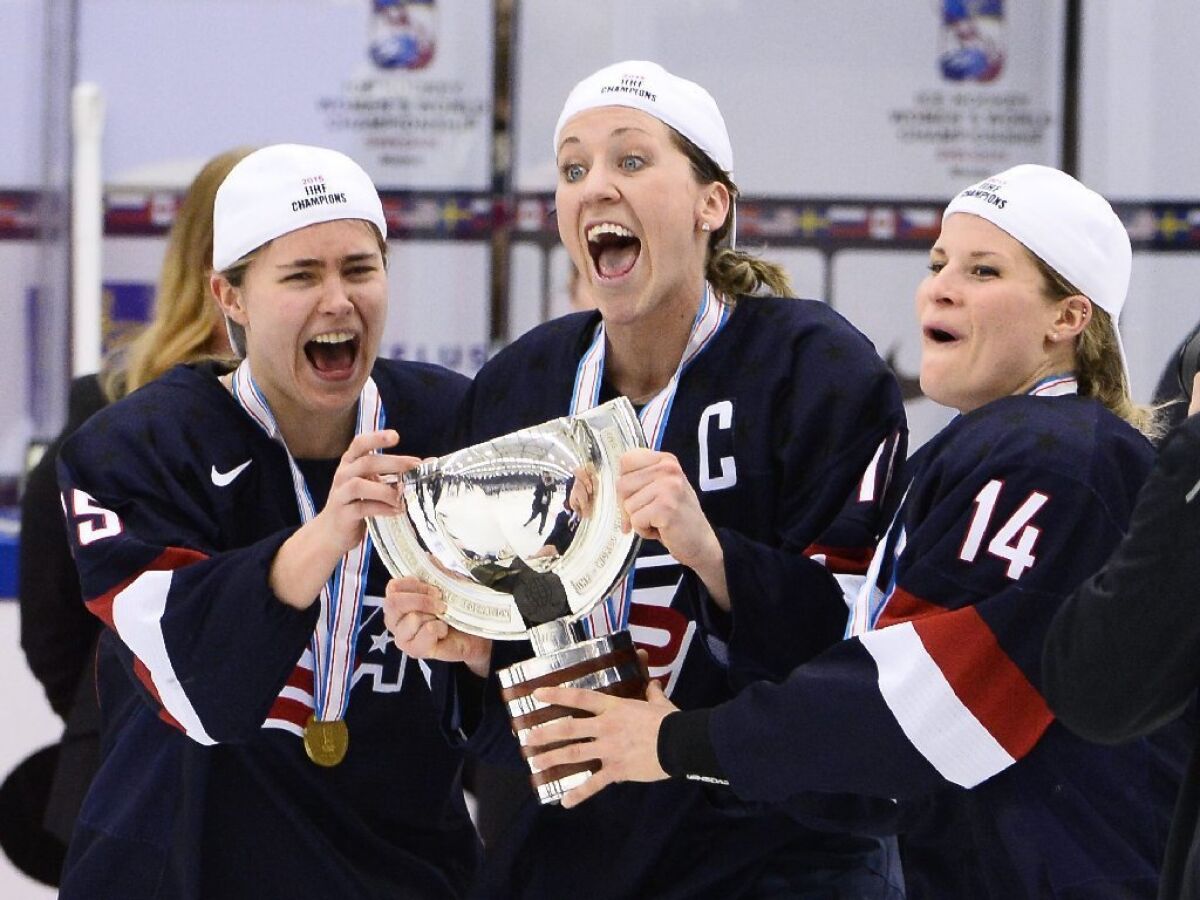 Team USA's Alex Carpenter, left, Meghan Duggan and Brianna Decker celebrate with the World Cup trophy after beating Canada, 7-5, in Saturday's gold medal match of the 2015 IIHF Ice Hockey Women's World Championship.