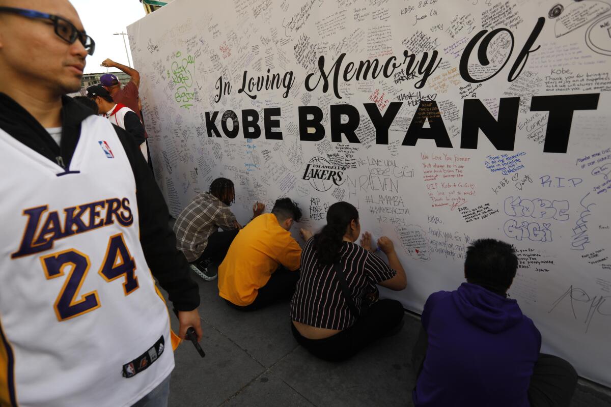Fans write personal memorials for Lakers legend Kobe Bryant at L.A. Live on Jan. 31, 2020.