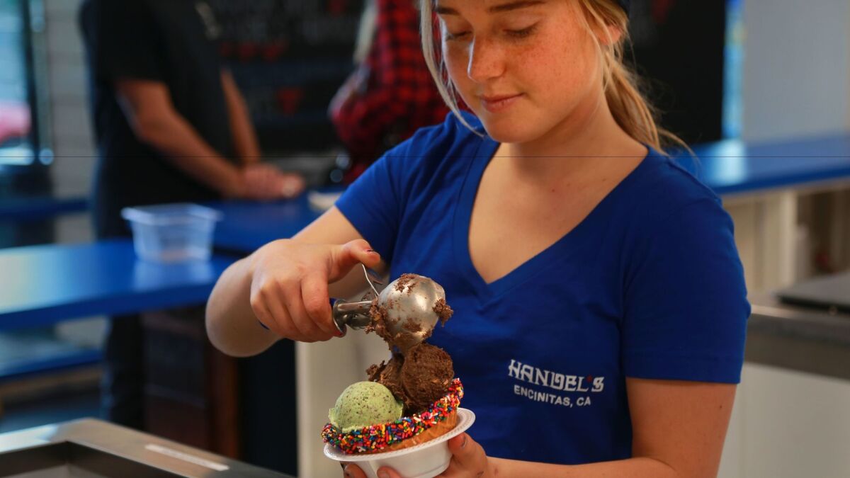 Elle Arnold dishes up a cup of ice cream at Handel's Homemade in Encinitas.