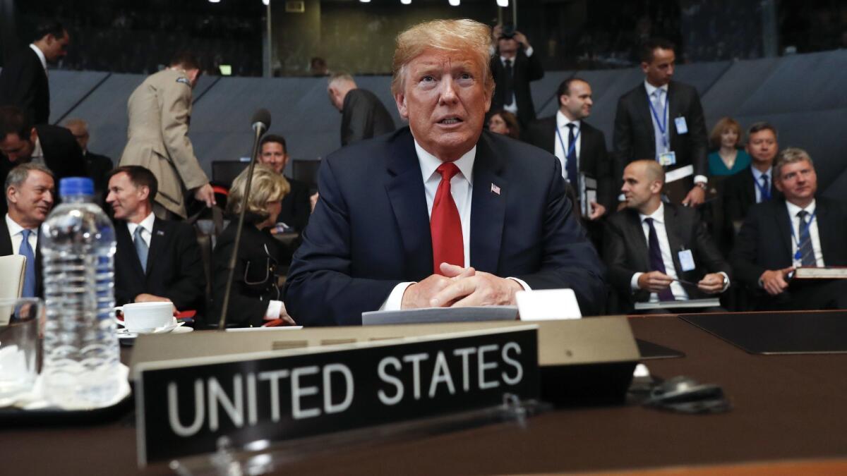 U.S. President Donald Trump takes his seat as he attends the multilateral meeting of the North Atlantic Council in Brussels, Belgium.