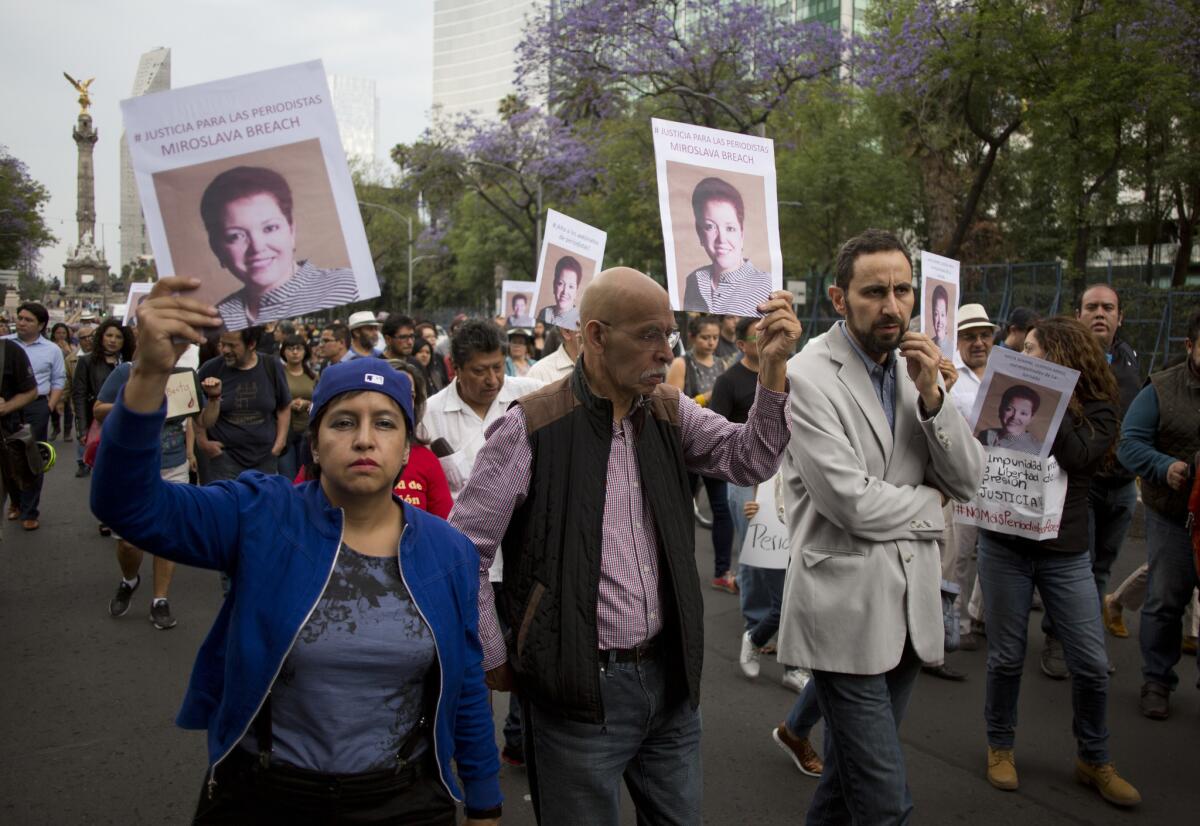 People hold photos of Mexican journalist Miroslava Breach, gunned down in March 2017 in the northern state of Chihuahua.