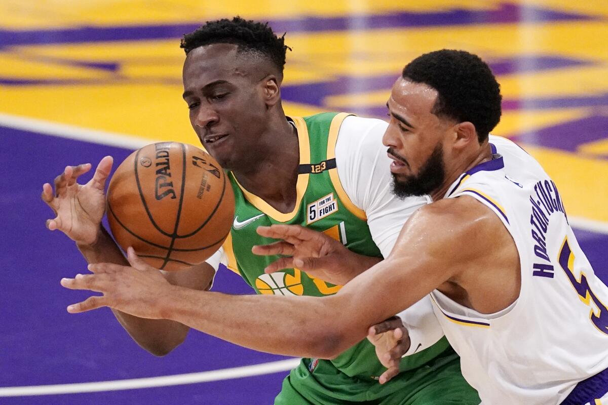 Utah Jazz guard Miye Oni and Lakers guard Talen Horton-Tucker battle for a loose ball.