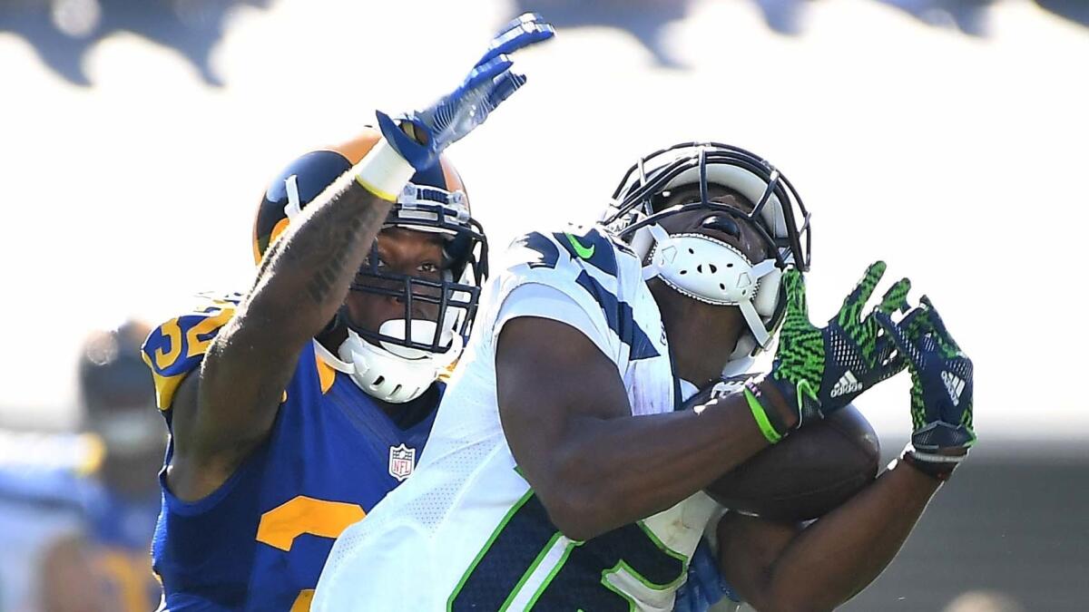 Seahawks receiver Tyler Lockett hauls in a long pass in front of Rams defensive back Troy Hill late in the fourth quarter on Sept. 18.