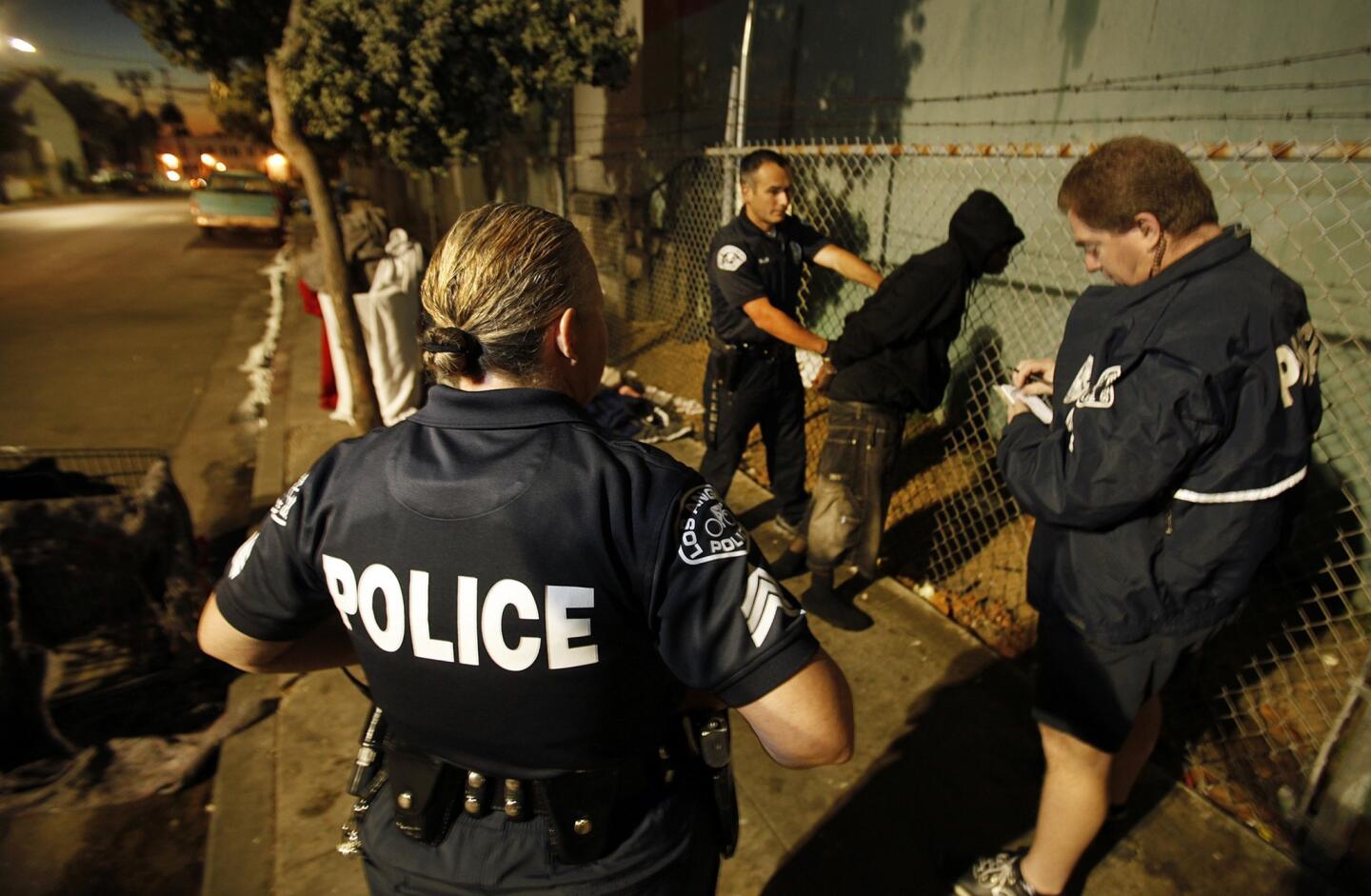 LAPD Sgt. Theresa Skinner, left, supervises as officers detain Chesnel Dorceus while waking up homeless people sleeping along 3rd near Rose Avenue. Under a 2007 court settlement, homeless people may sleep on sidewalks in the city of Los Angeles as long as they move on by 6 a.m. When they don't, officers may find themselves on wake-up patrol.