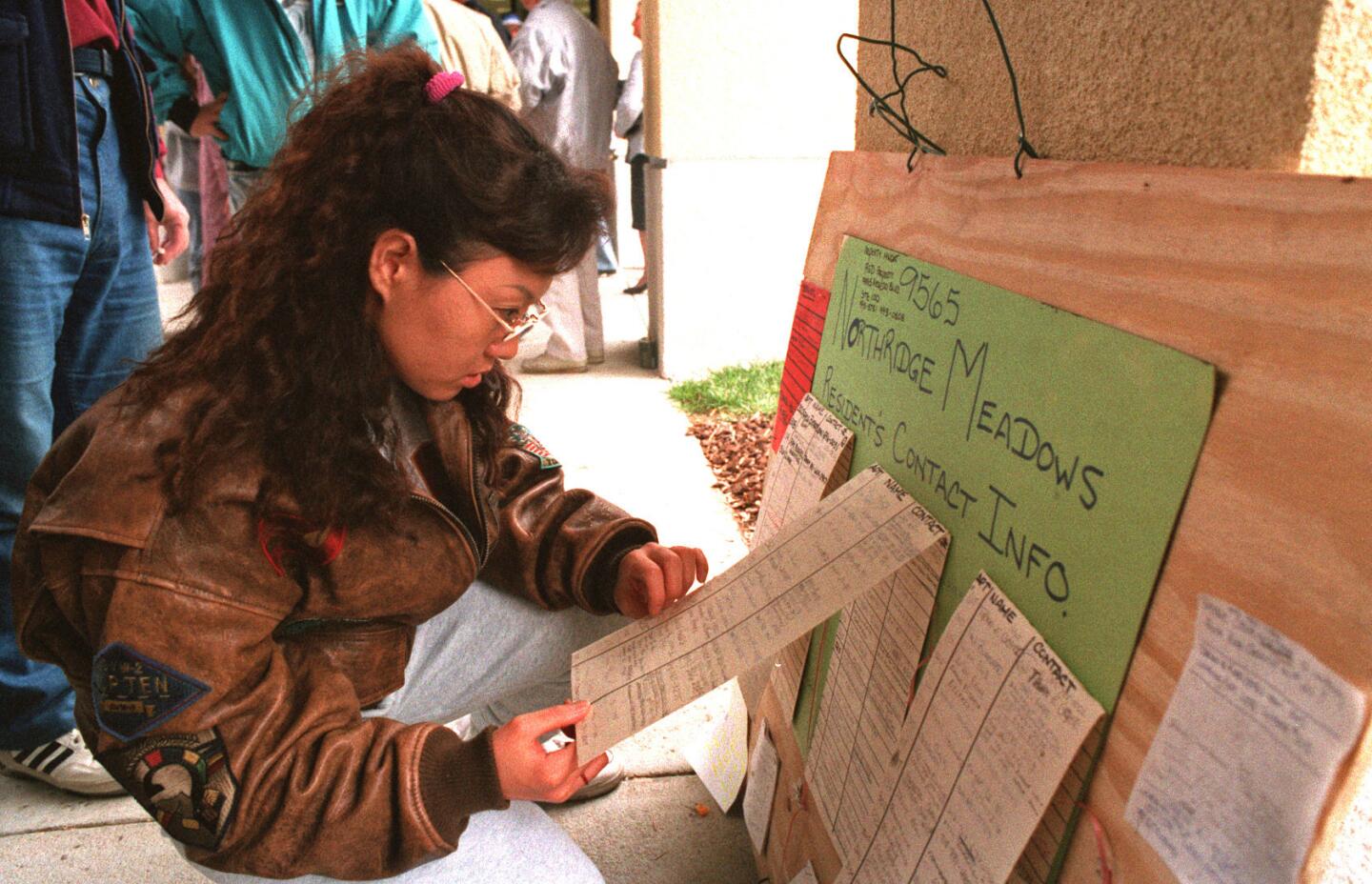 Jiyoun Sim checks a list of Northridge Meadows survivors at a church.