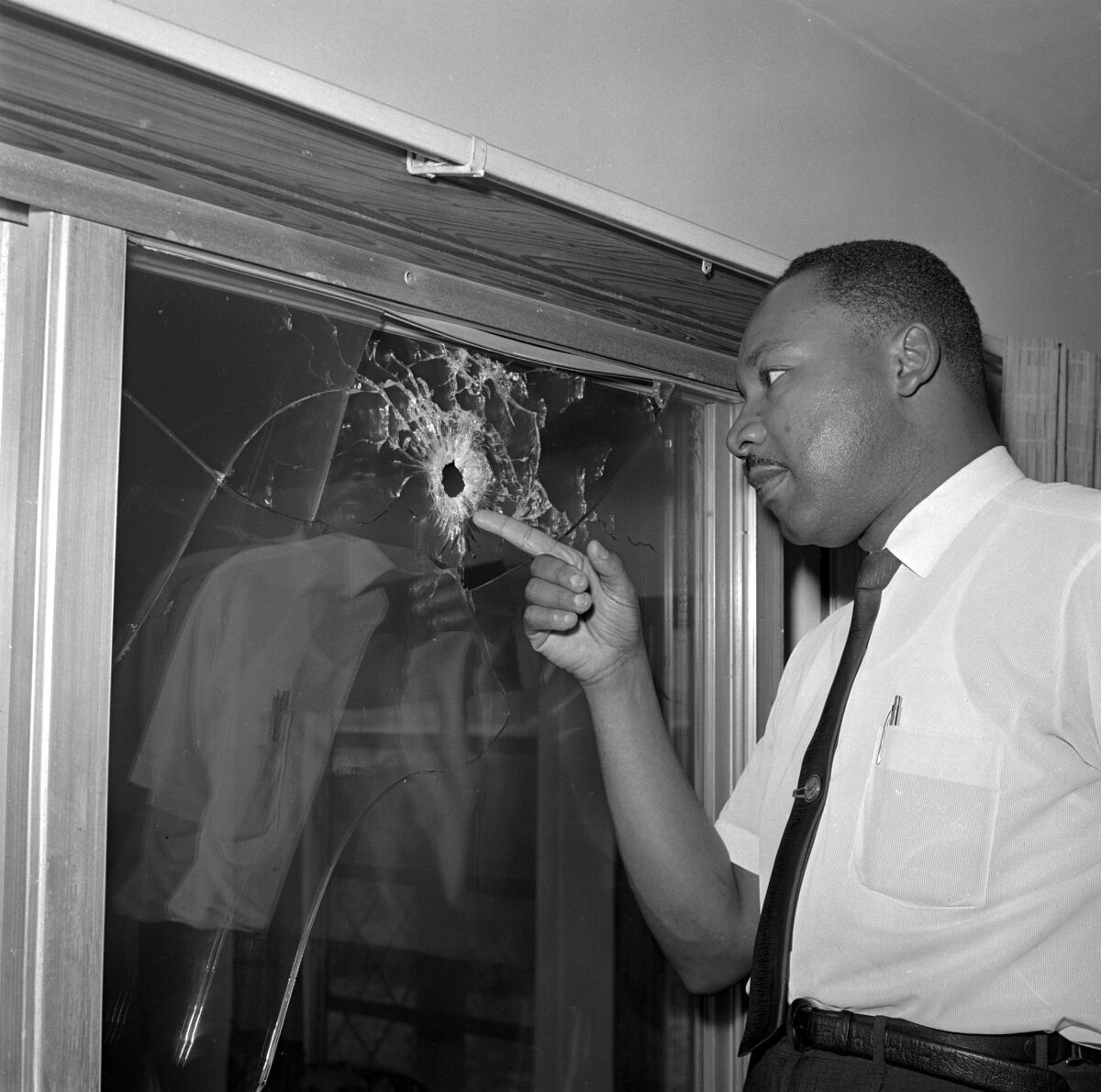 FILE - In this June 5, 1964, file photo, Dr. Martin Luther King Jr. looks at a glass door of his rented beach cottage in St. Augustine, Fla., that was shot into. The house connected to King is now in the hands of a couple who plans to preserve it. David Manaute and Patti Barry live in the house on the coastline south of St. Augustine. (AP Photo/Jim Kerlin, File)