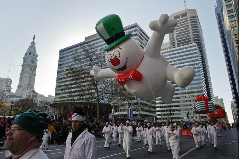 The Frosty the Snowman balloon make its way down 16th Street in view of City Hall during the 93rd annual Thanksgiving day parade, Thursday Nov. 22, 2012, in Philadelphia .New York, Chicago, and Detroit are also among the cities hosting holiday parades. (AP Photo/Joseph Kaczmarek)