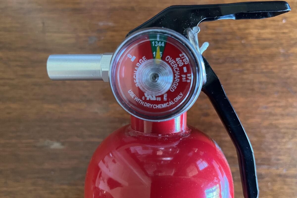 Close up photograph of a fire extinguisher gauge indicating a usable amount of pressure in the canister.