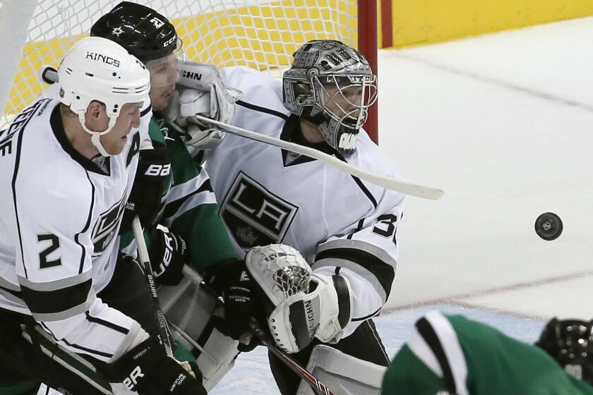 Kings goalie Jonathan Quick, center, and defenseman Matt Greene, right, battle Dallas Stars forward Antoine Roussel for a rebound during the first period of the Kings' 5-4 loss Saturday.