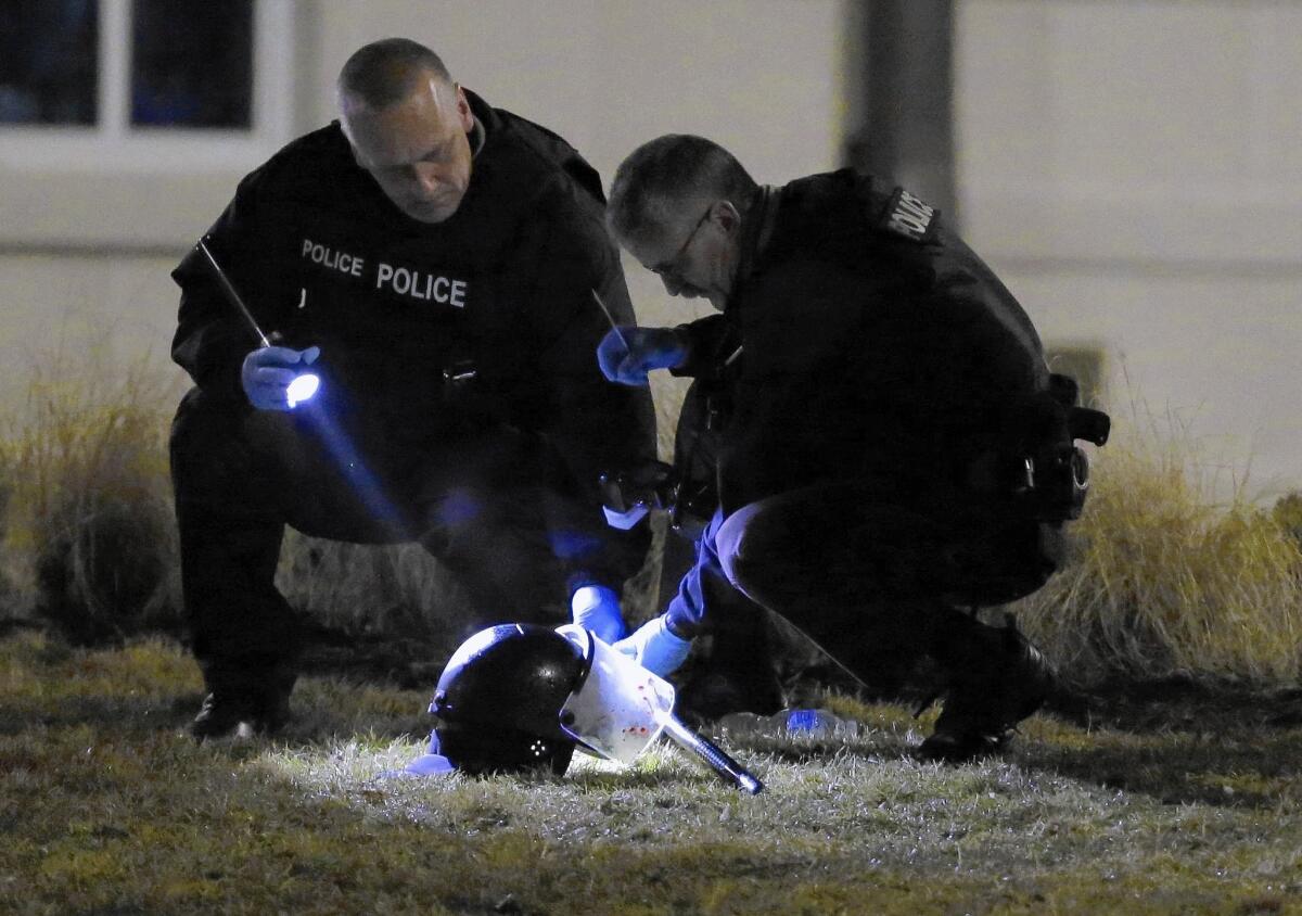 Police investigators gather evidence after two officers were shot after a night of protest in Ferguson.