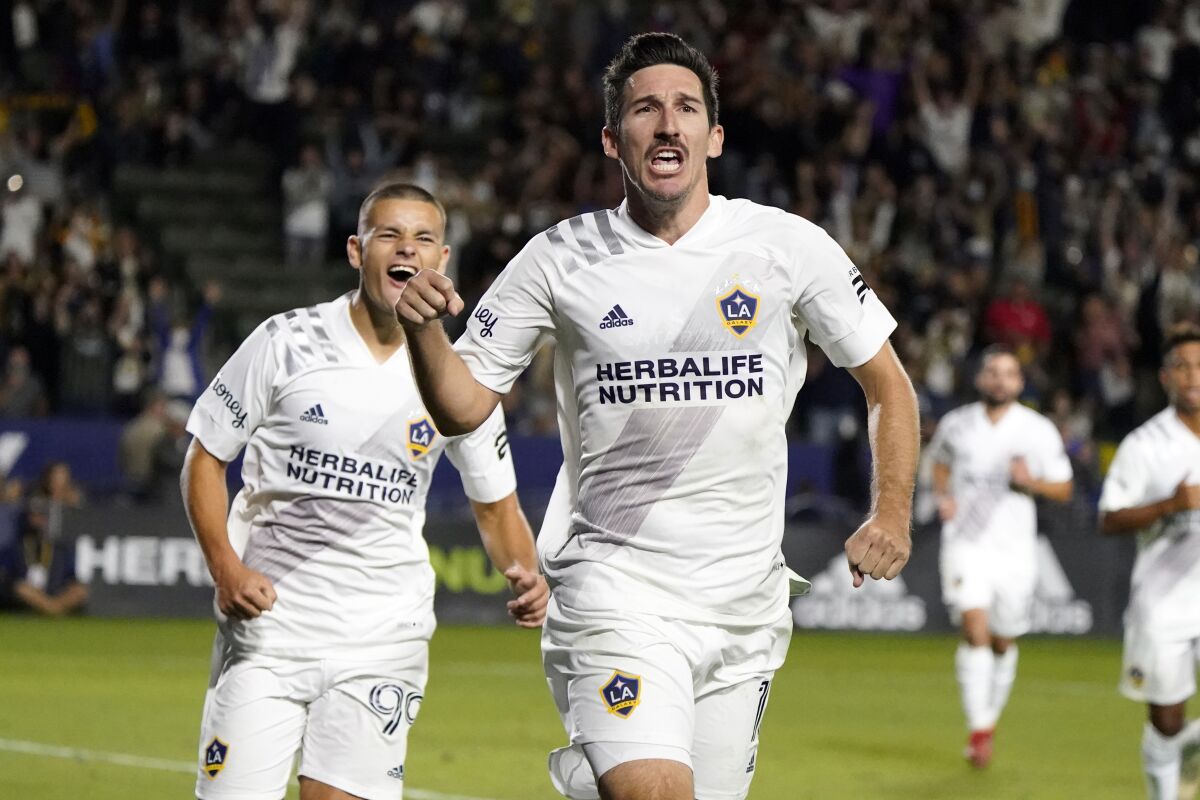 LA Galaxy midfielder Sacha Kljestan, center, celebrates after scoring on a penalty kick against the Portland Timbers during the second half of an MLS soccer match Saturday, Oct. 16, 2021, in Carson, Calif. (AP Photo/Marcio Jose Sanchez)