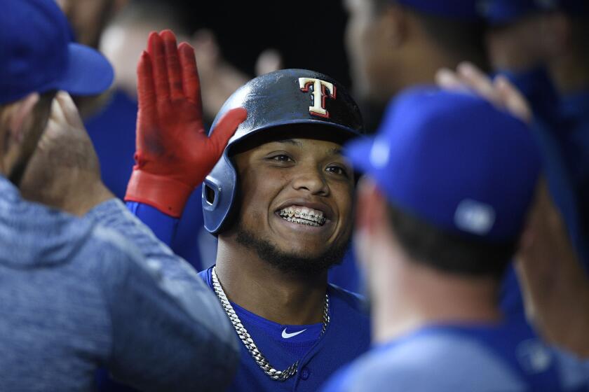 Texas Rangers' Willie Calhoun celebrates his home run in the dugout during the first inning of a baseball game against the Baltimore Orioles, Friday, Sept. 6, 2019, in Baltimore. (AP Photo/Nick Wass)