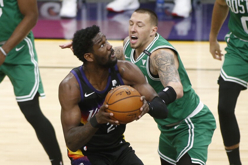 Phoenix Suns center Deandre Ayton, left, looks to shoot as Boston Celtics forward Daniel Theis defends during the first half of an NBA basketball game, Sunday, Feb. 7, 2021, in Phoenix. (AP Photo/Ralph Freso)