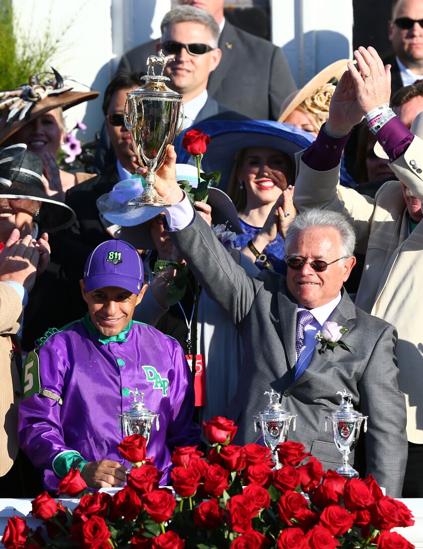 Jockey Victor Espinoza (left) and Trainer Art Sherman celebrate after California Chrome's win in the 2014 Kentucky Derby.
