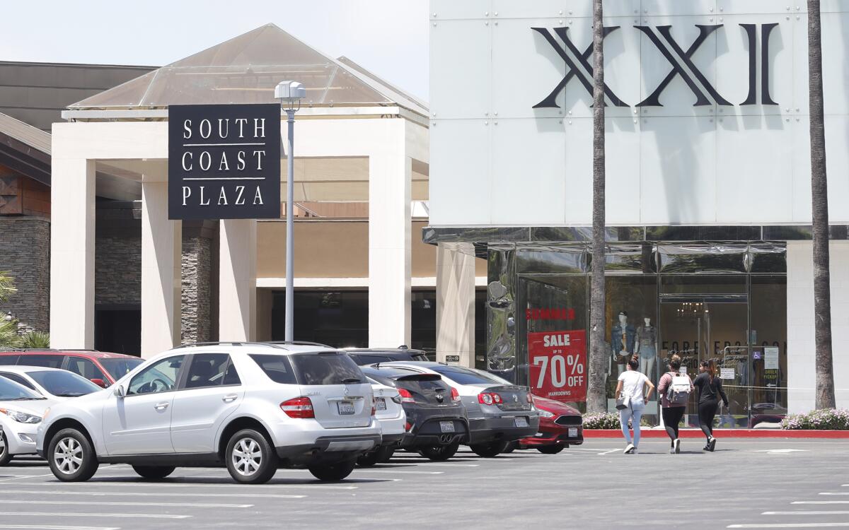 Shoppers walk towards South Coast Plaza's east entrance Tuesday.